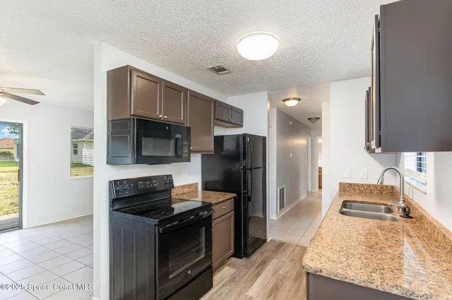 a kitchen with stainless steel appliances granite countertop a stove refrigerator and microwave