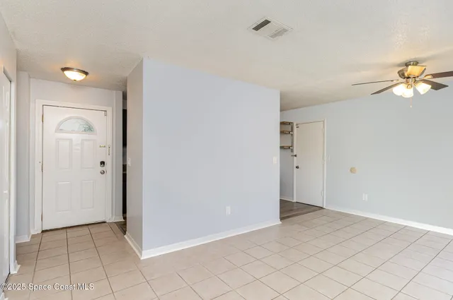 an empty room with closet and a chandelier fan