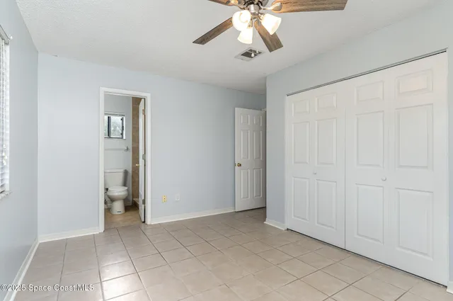 a view of an empty room and chandelier fan