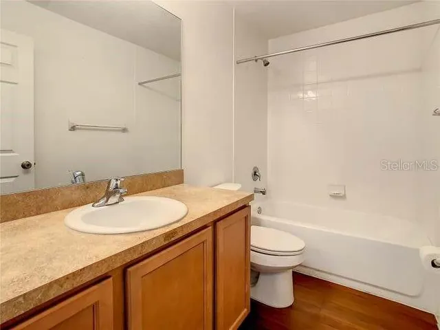 a bathroom with a granite countertop sink toilet and mirror