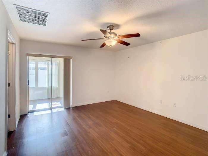 2685 Shelby Ruth Place St. Cloud, FL 34769 - Photo 5 of 16 an empty room with wooden floor fan and windows