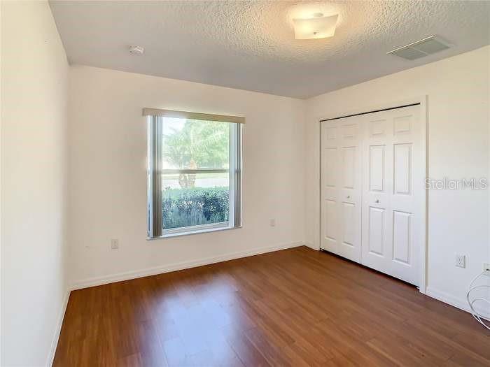 2685 Shelby Ruth Place St. Cloud, FL 34769 - Photo 7 of 16 an empty room with wooden floor and windows
