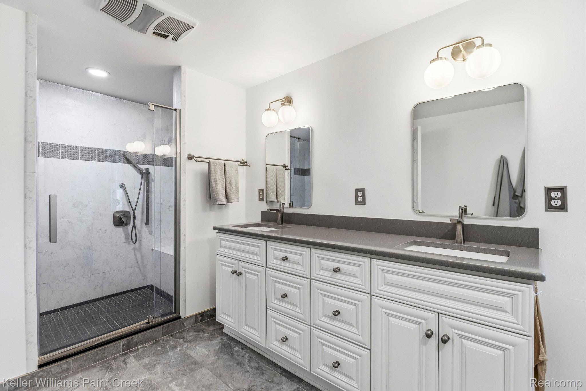 1675 North Kilburn Road Rochester, MI 48306 - Photo 39 of 48 Dual vanity with white cabinetry and dark countertops