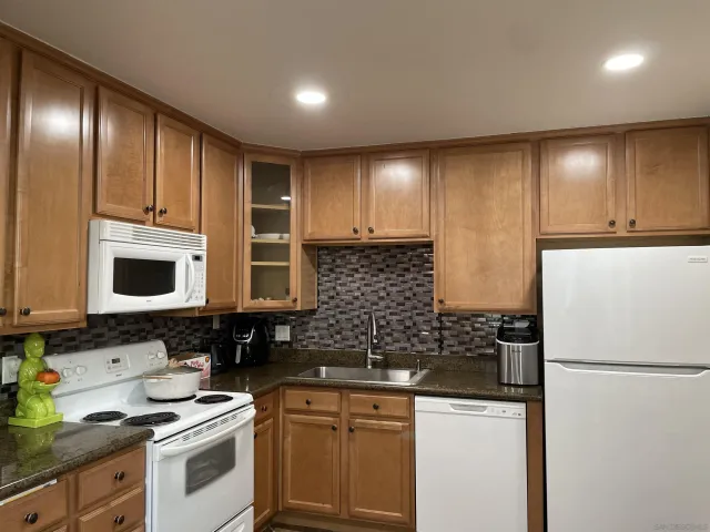 a kitchen with stainless steel appliances granite countertop a refrigerator sink and cabinets