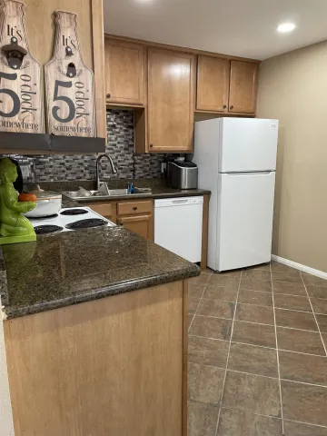 a kitchen with stainless steel appliances granite countertop a sink a stove a refrigerator a microwave and cabinets