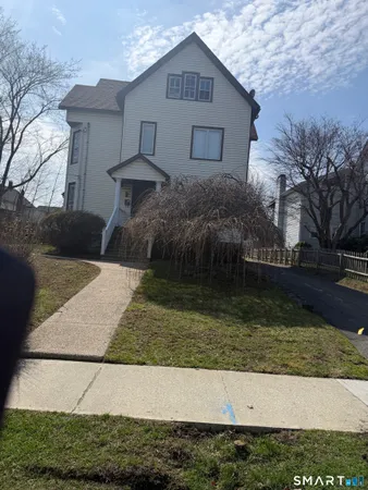 a front view of house with yard and trees