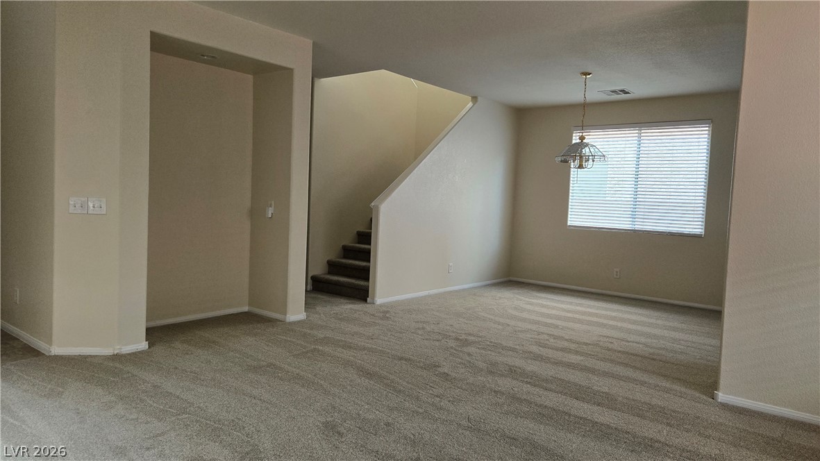 9031 Spring Star Court Las Vegas, NV 89148 - Photo 4 of 17 A well-lit living space with plush carpeting, offering a seamless transition to the upstairs area.