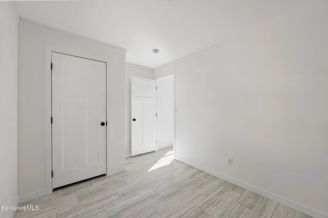 a view of an empty room with wooden floor