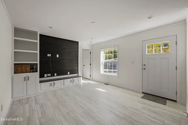 an empty room with windows and cabinet