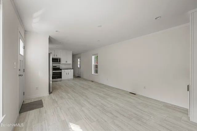 a view of empty room with wooden floor