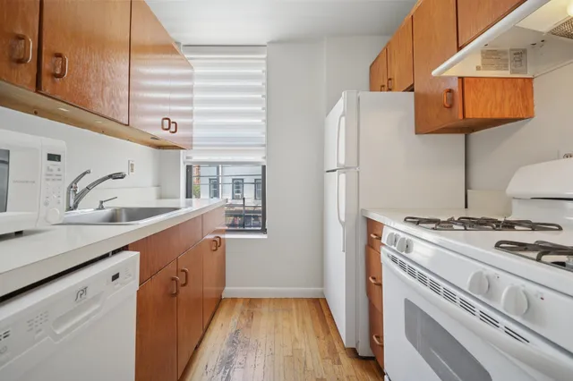 a kitchen with stainless steel appliances granite countertop a sink a stove and a refrigerator