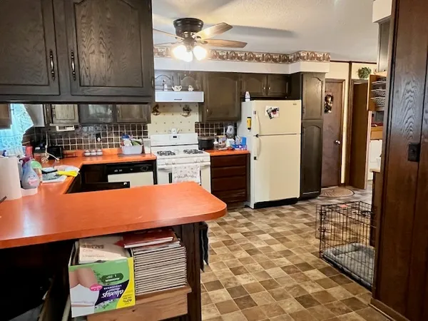 a kitchen with stainless steel appliances granite countertop a refrigerator and a stove top oven