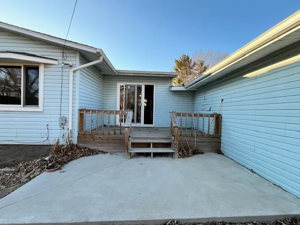 a view of a patio with table and chairs with wooden floor and fence