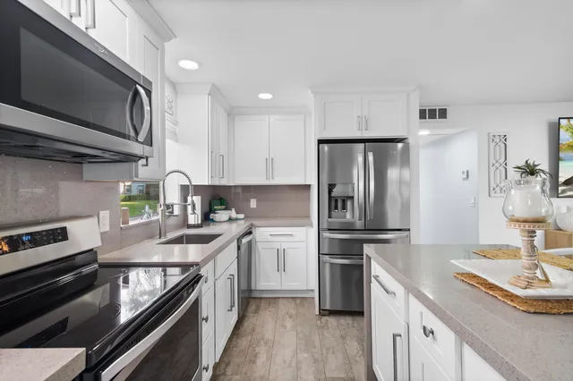 a kitchen with white cabinets and stainless steel appliances