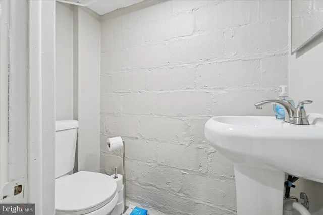 a bathroom with a sink a toilet and a mirror