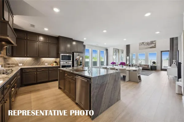 a large kitchen with stainless steel appliances granite countertop a sink stove and refrigerator
