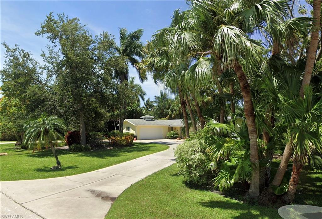 289 Springline Drive Naples, FL 34102 - Photo 9 of 9 a view of a yard with plants and trees