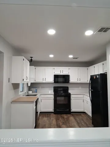 a kitchen with a refrigerator and a stove top oven