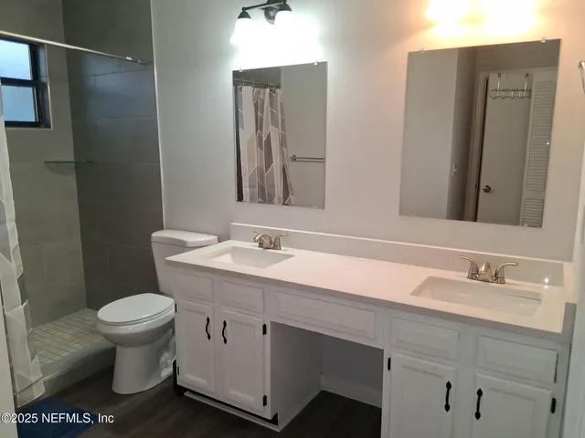 a bathroom with a toilet sink and mirror