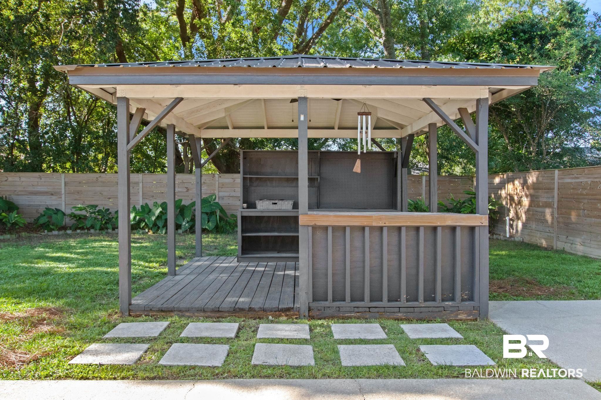 524 Ariel Avenue Foley, AL 36535 - Photo 28 of 37 Covered outdoor structure featuring a wood-finish deck, built-in shelving, and a bar counter