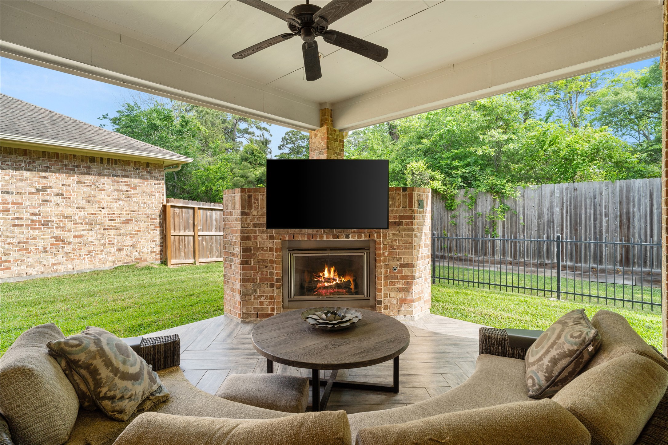 19813 Cullen Ridge Drive Porter, TX 77365 - Photo 42 of 44 This inviting outdoor space features a cozy fireplace, perfect for relaxing evenings and entertaining guests, elevating your home experience.