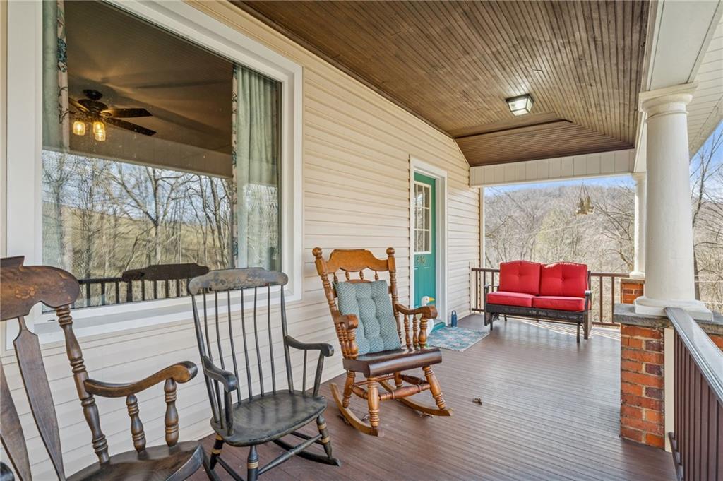 416 Pine Run Road Fombell, PA 16123 - Photo 2 of 50 a balcony with furniture and wooden floor