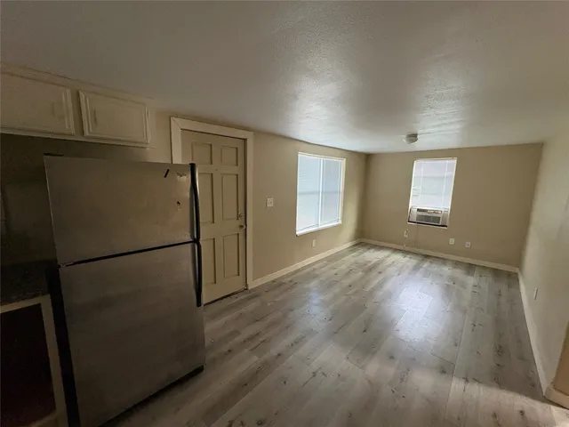 a view of empty room with wooden floor and cabinets