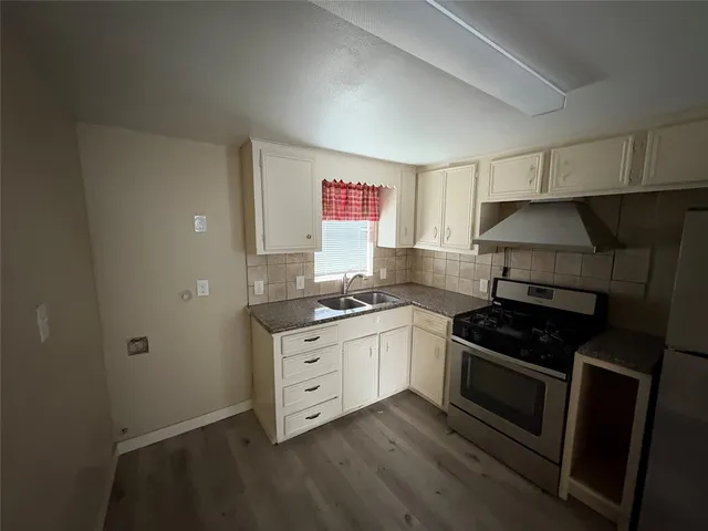 a kitchen with granite countertop a stove and a sink