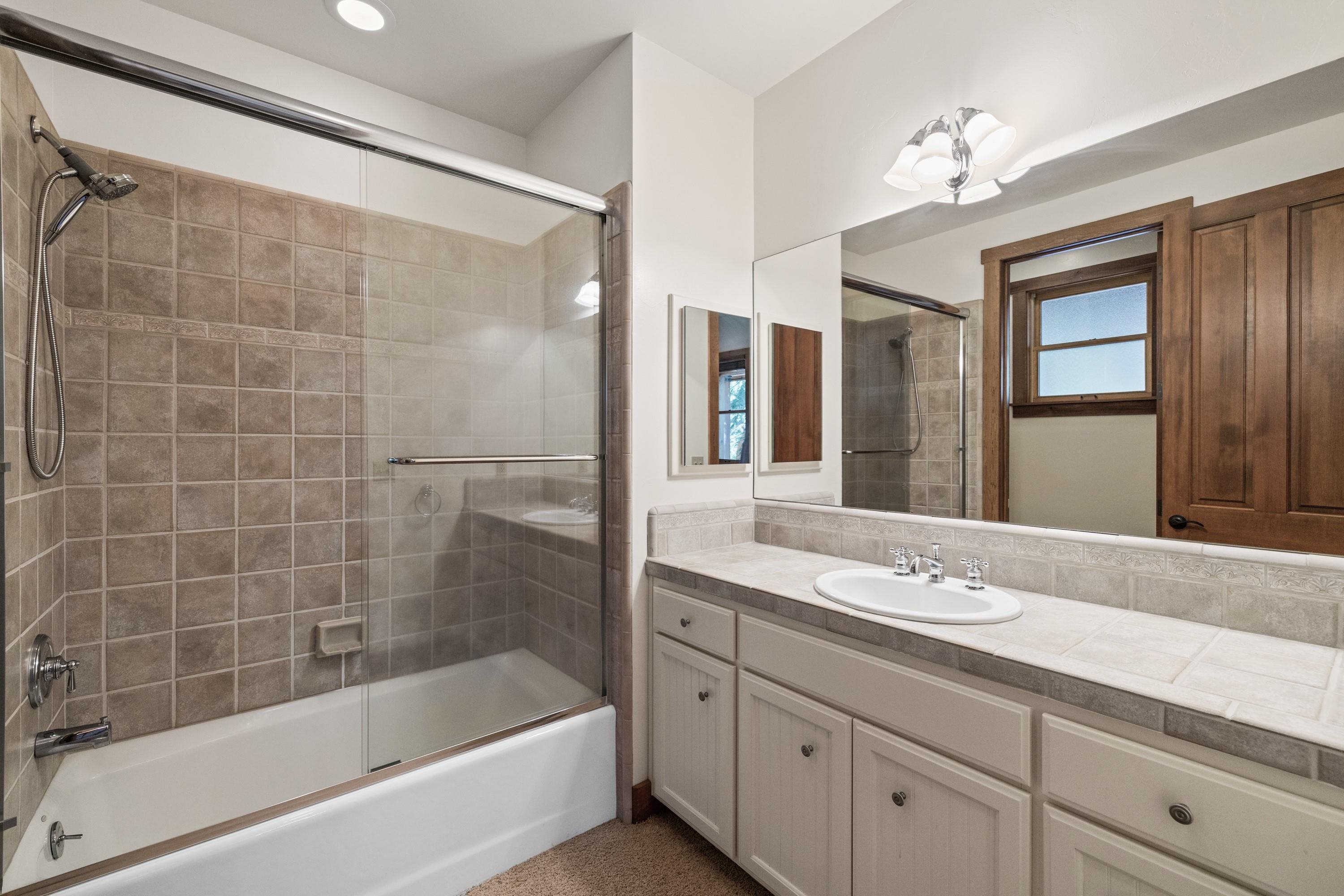 1940 Gray Wolf Truckee, CA 96161 - Photo 17 of 20 a bathroom with a bathtub shower sink vanity and mirror
