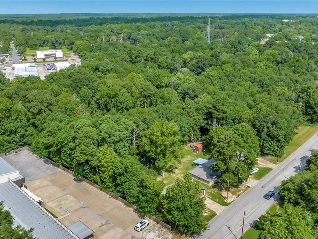 an aerial view of residential houses with outdoor space and trees