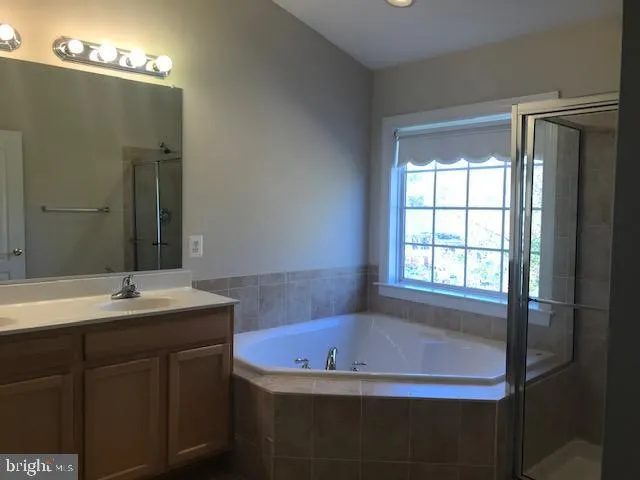 a bathroom with a sink double vanity granite tub and shower