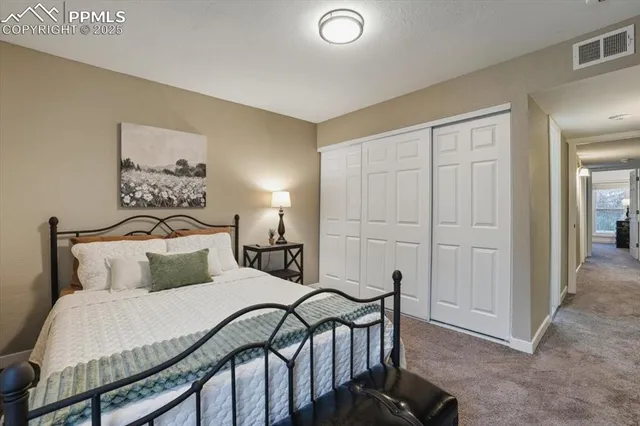 a bedroom with a bed and a painting on the wall