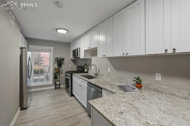 a kitchen with stainless steel appliances granite countertop a stove a sink and a refrigerator