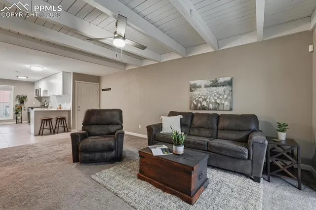 a living room with furniture and kitchen view