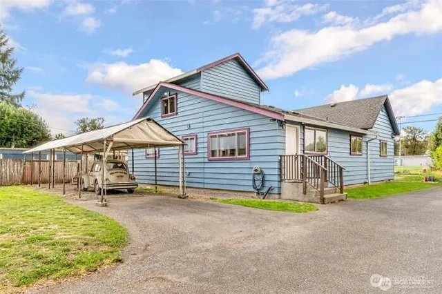 a view of a house with a yard patio and wooden fence