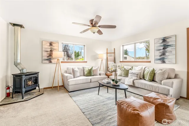 a living room with furniture a ceiling fan and a window