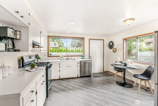a kitchen with granite countertop a sink stove and cabinets