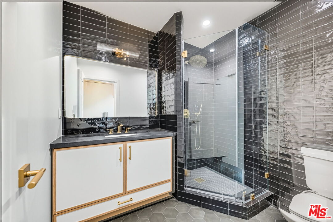 6327 Babcock Avenue Valley Glen, CA 91606 - Photo 15 of 21 a bathroom with a granite countertop sink a toilet and a mirror