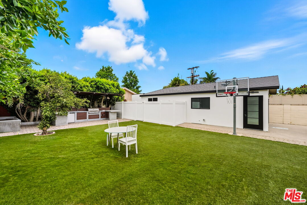 6327 Babcock Avenue Valley Glen, CA 91606 - Photo 4 of 21 a white house with a big yard and a large tree