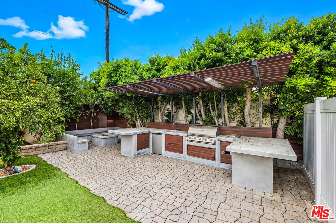 6327 Babcock Avenue Valley Glen, CA 91606 - Photo 6 of 21 a view of a patio with table and chairs potted plants and palm tree