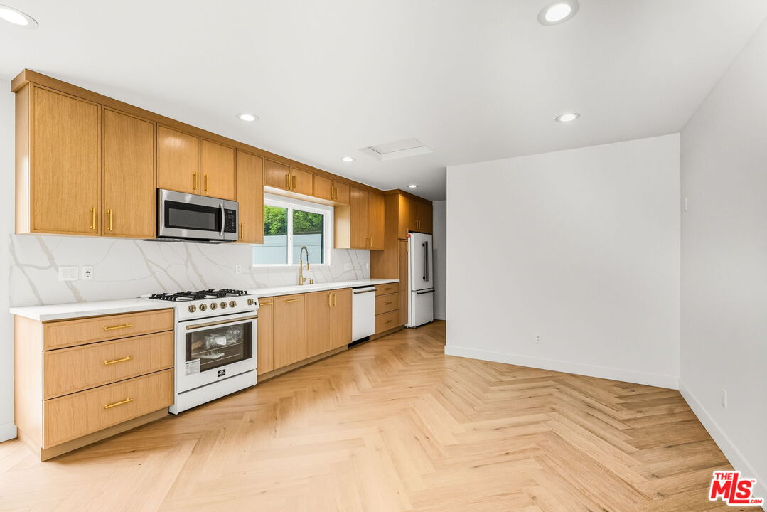6327 Babcock Avenue Valley Glen, CA 91606 - Photo 9 of 21 a kitchen with stainless steel appliances granite countertop a stove a sink and a microwave