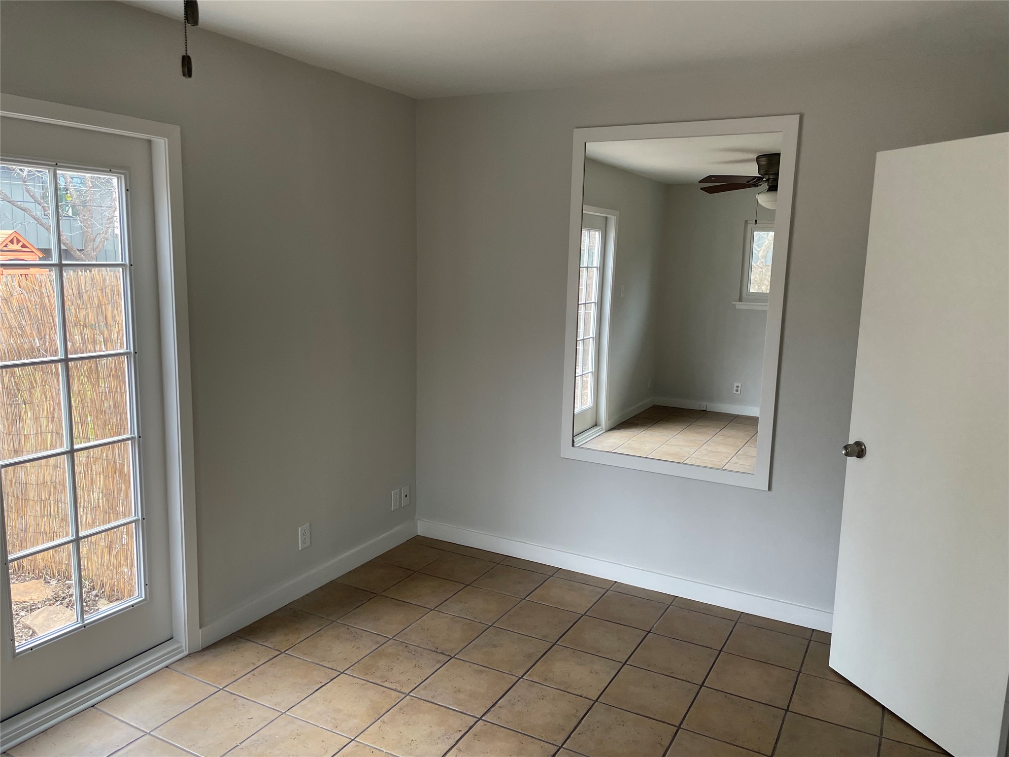 4619 Jinx Avenue, Unit A Austin, TX 78745 - Photo 10 of 21 Room featuring ceramic tile flooring, a white-framed glass-paneled door, and a built-in wall mirror