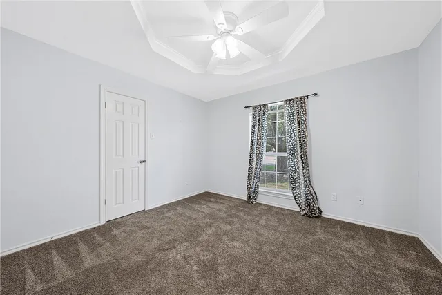 an empty room with a windows and ceiling fan