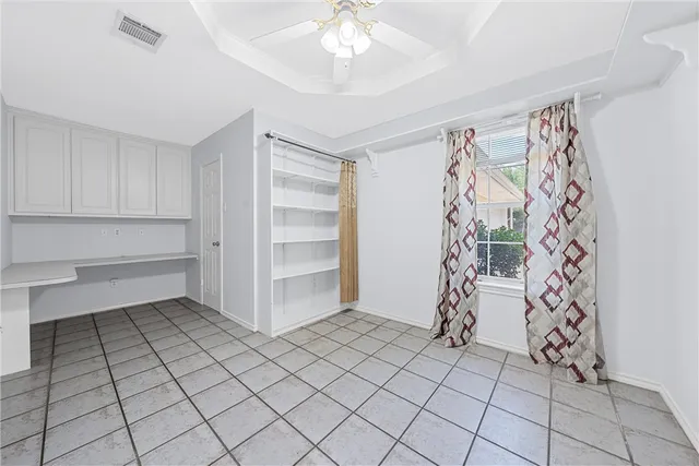 a view of empty room with cabinet and fan