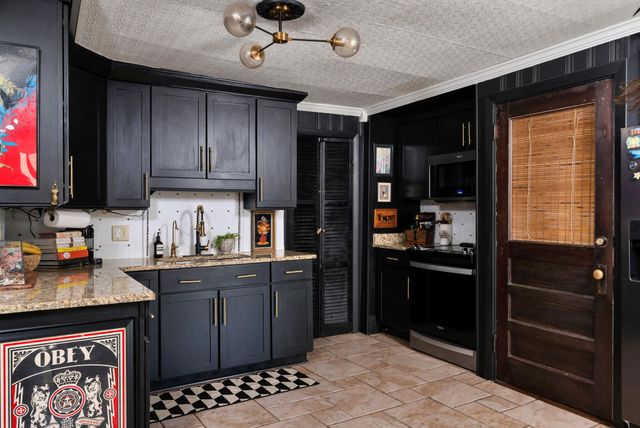 a kitchen with stainless steel appliances granite countertop a refrigerator and a stove top oven