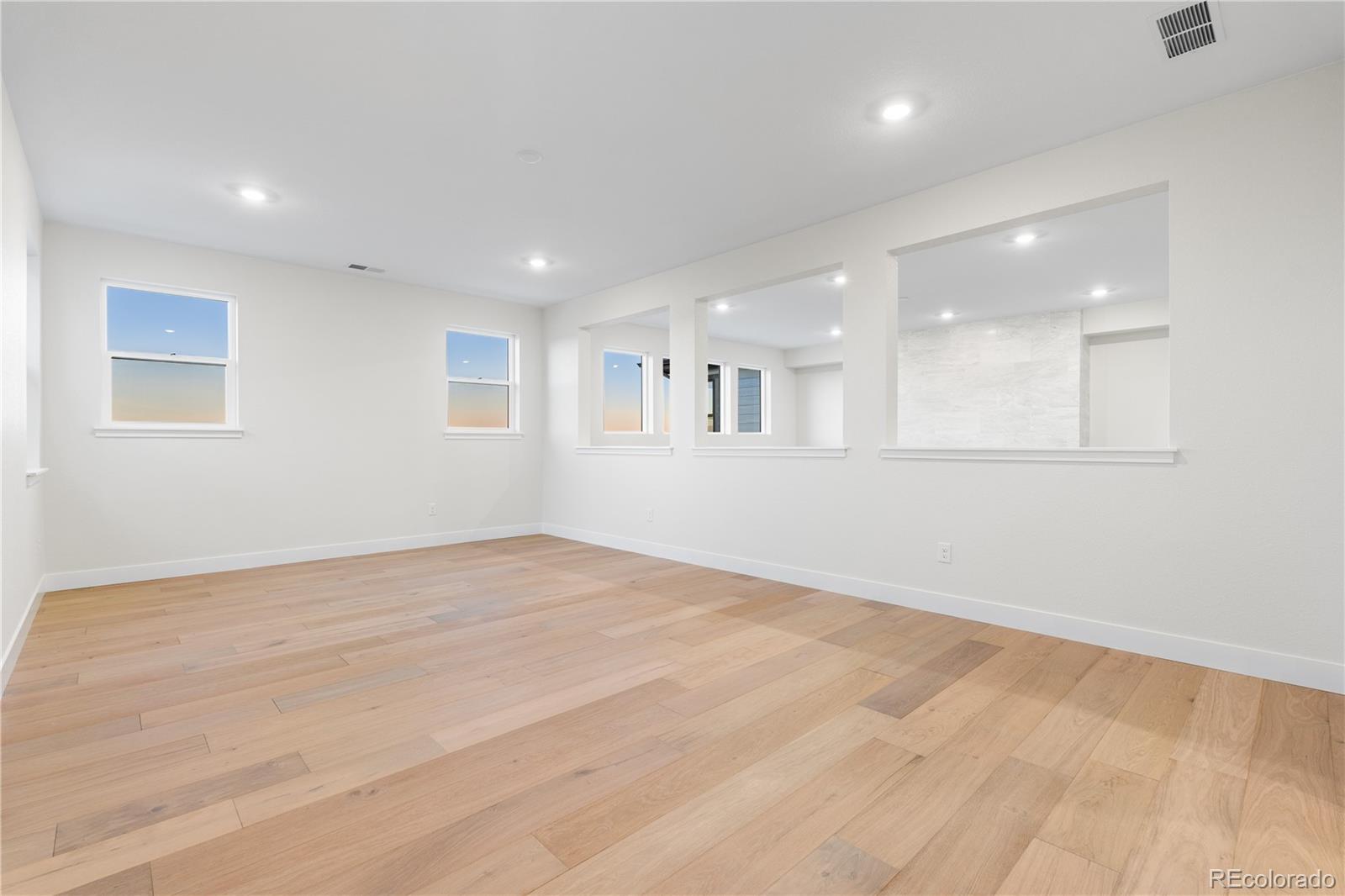 11283 Tenor Trail Lone Tree, CO 80134 - Photo 21 of 47 an empty room with wooden floor and windows