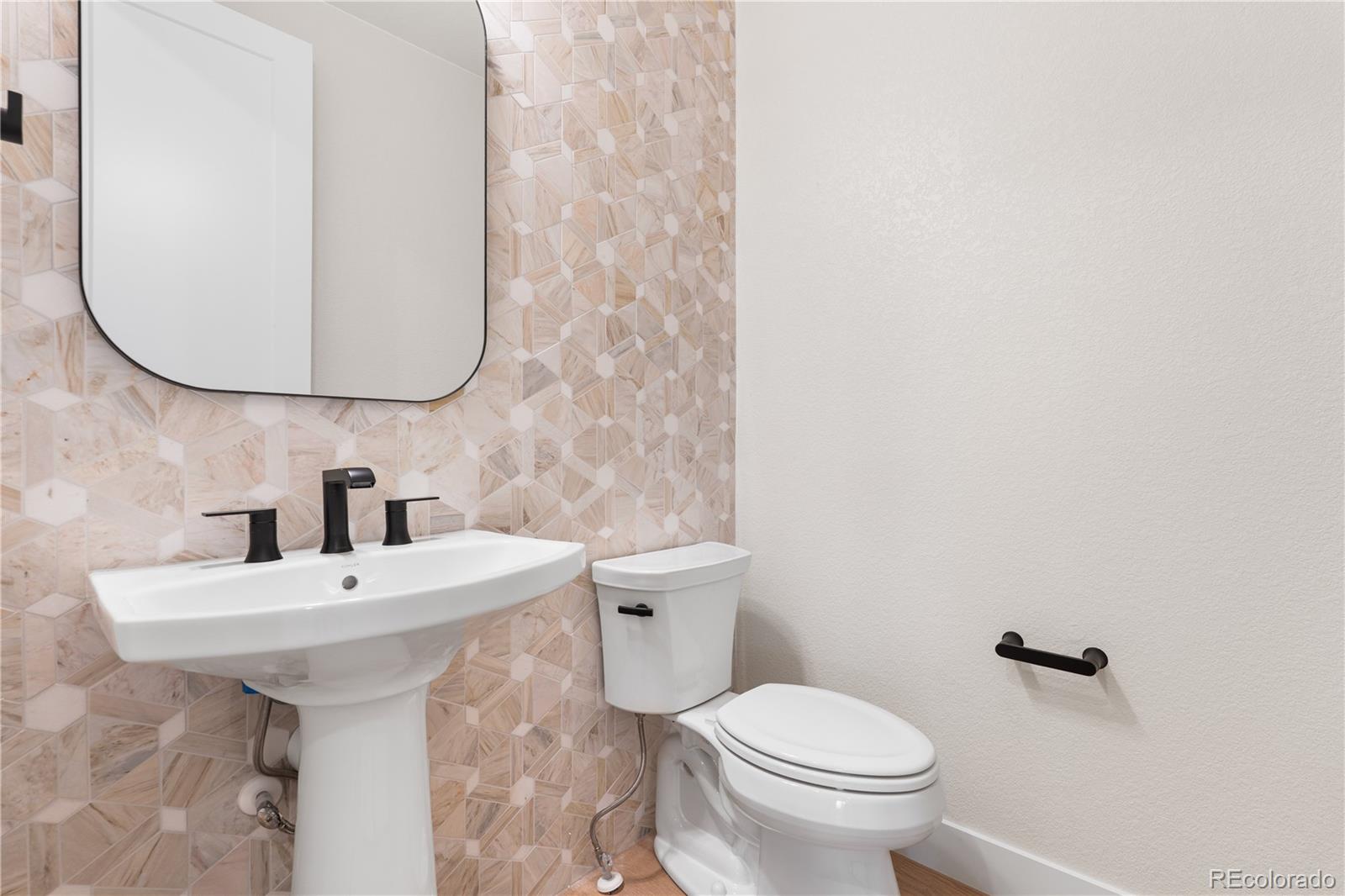 11283 Tenor Trail Lone Tree, CO 80134 - Photo 30 of 47 a bathroom with a sink a toilet and mirror