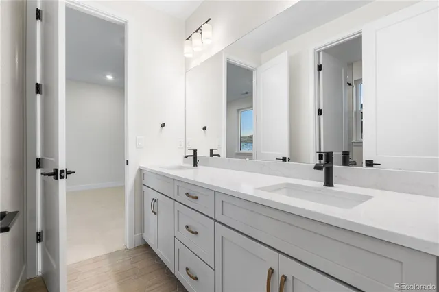 a bathroom with double vanity sinks and a mirror