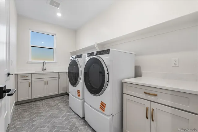 a utility room with sink dryer and washer