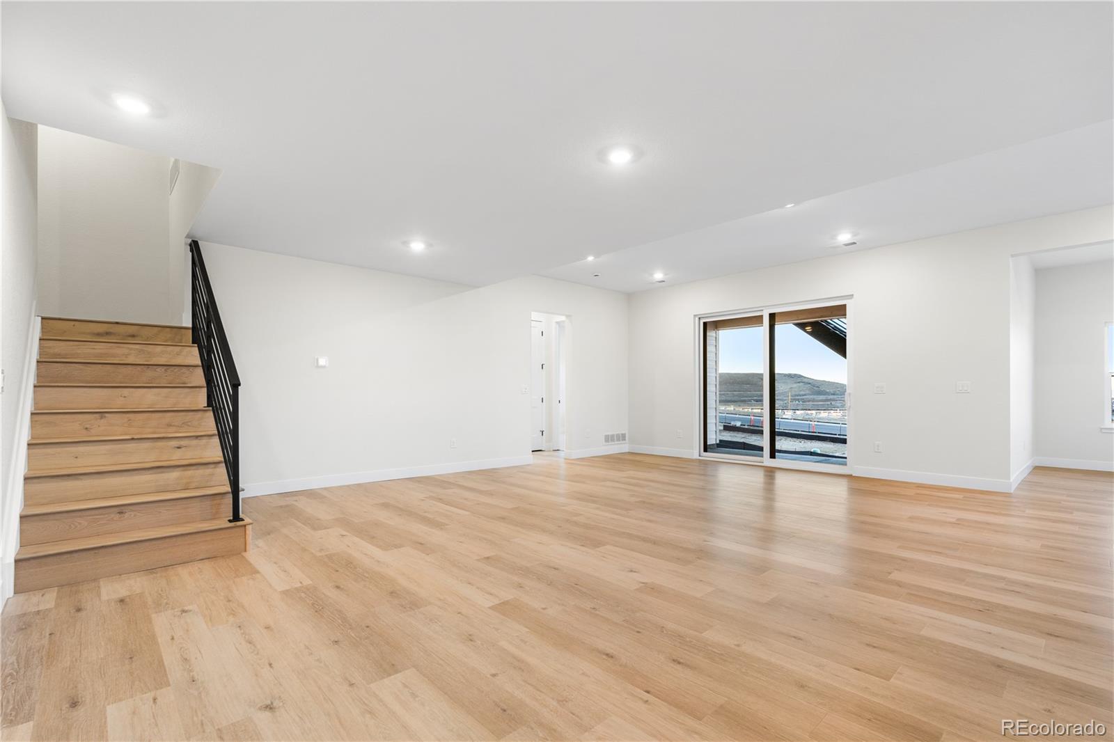 11283 Tenor Trail Lone Tree, CO 80134 - Photo 5 of 47 a view of an empty room with wooden floor and stairs
